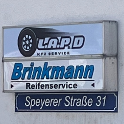 Firmenschild an einer Hauswand mit den Aufschriften L.A.P.D Kfz Service, Brinkmann Reifenservice und Speyerer Straße 31.