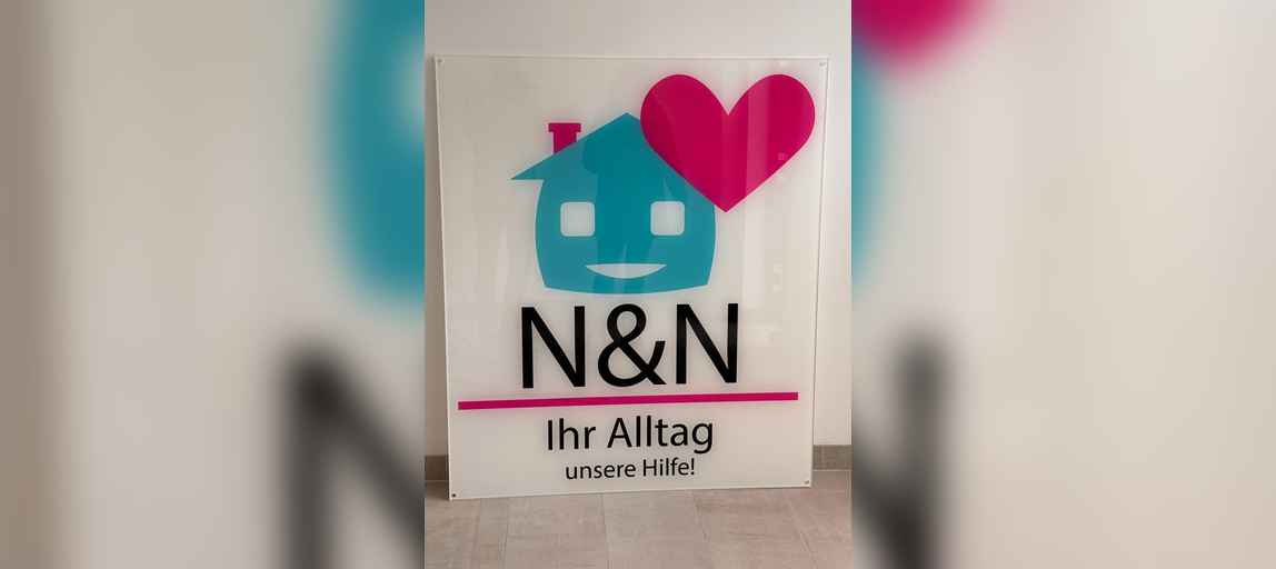 Schild mit Haus- und Herzsymbol sowie dem Schriftzug N&N Ihr Alltag unsere Hilfe
