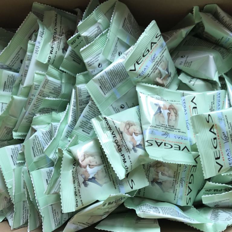 Viele mintgrüne einzeln verpackte Feuchttücher in einer offenen Kiste.