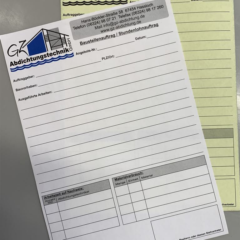 Zwei leere Formulare von GZ Abdichtungstechnik liegen übereinander auf einer grauen Oberfläche.